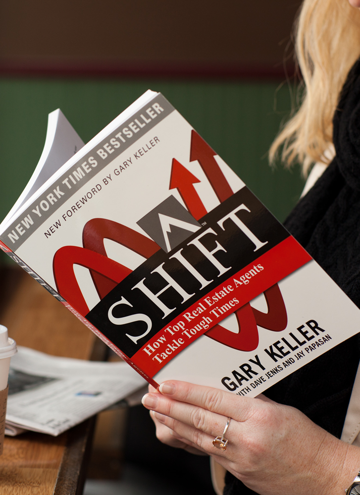 woman in coffee shop reading the book SHIFT by Gary Keller