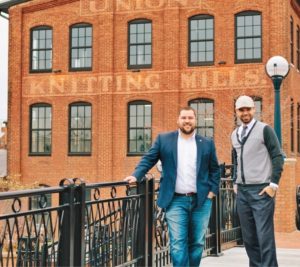 real estate agents Cory Wilson and Drew Hopley posing in front of a building